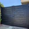 Black aluminum horizontal slat semi-privacy double gate, modern sleek design with 6 inch slats, provides privacy, security, and easy DIY installation for homeowners