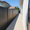 6-foot modern aluminum slat fence providing privacy in residential side walkway