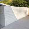 Stylish backyard patio enclosed with low-maintenance white aluminum slat fence